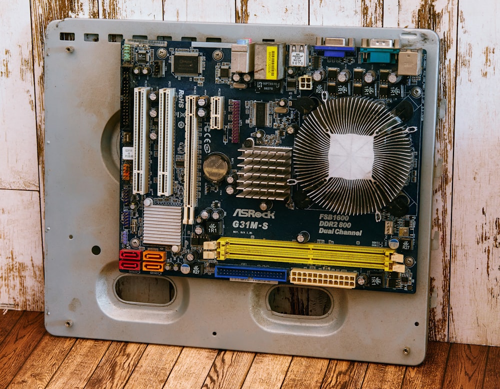a computer motherboard sitting on top of a wooden floor