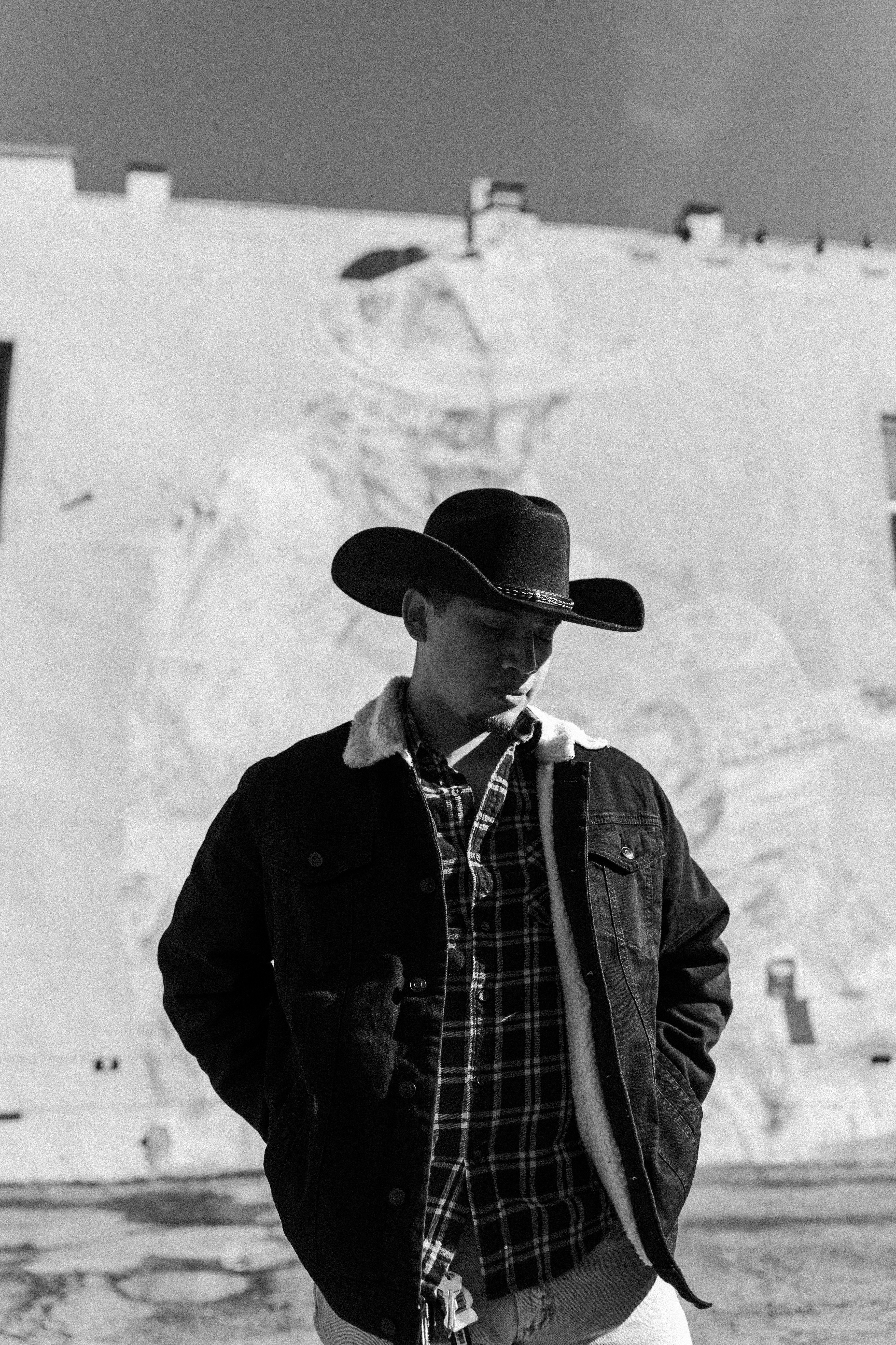 A man wearing a cowboy hat standing in front of a building photo – Free ...