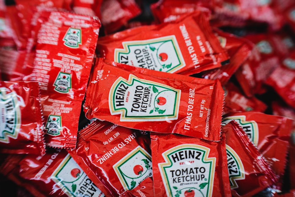 a pile of red packets of tomato ketchup