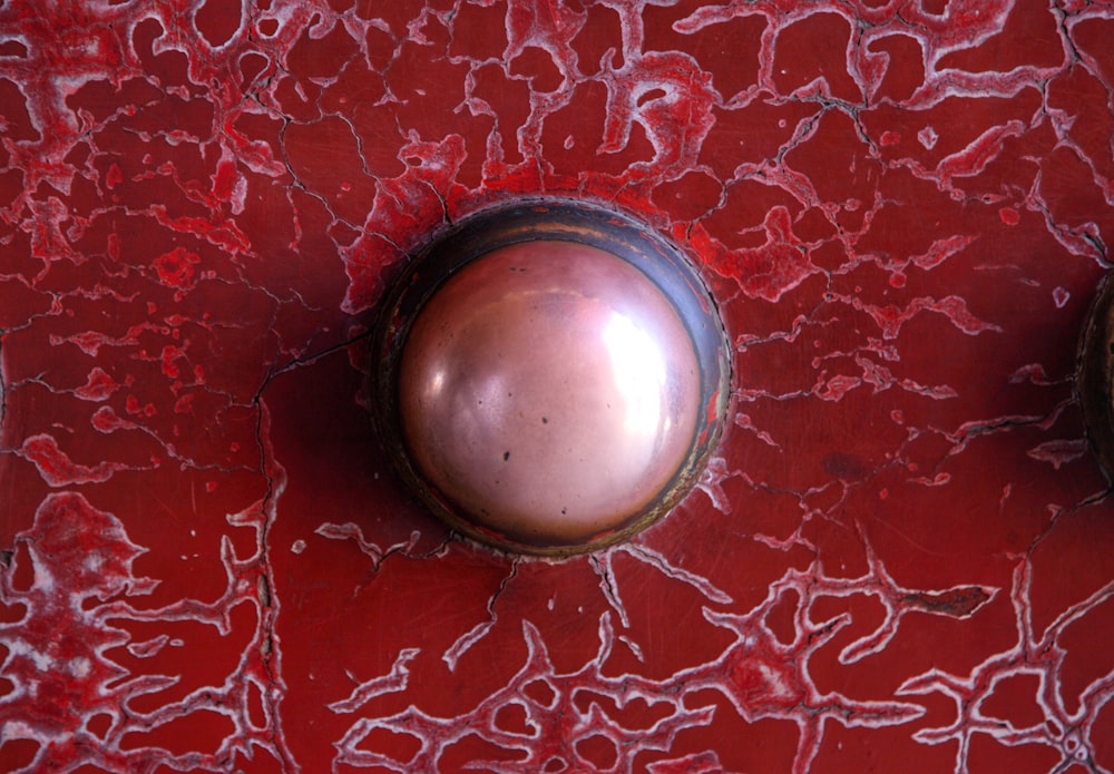 two metal knobs on a red surface