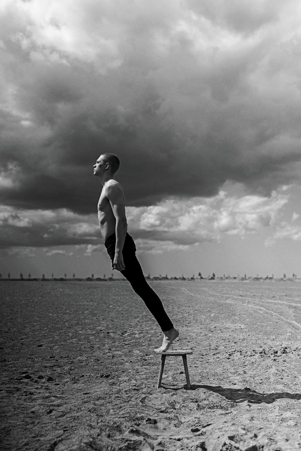 a man standing on a stool on a beach
