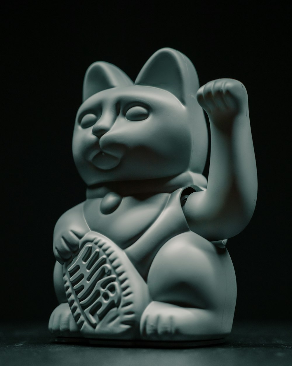 a white cat figurine sitting on top of a table