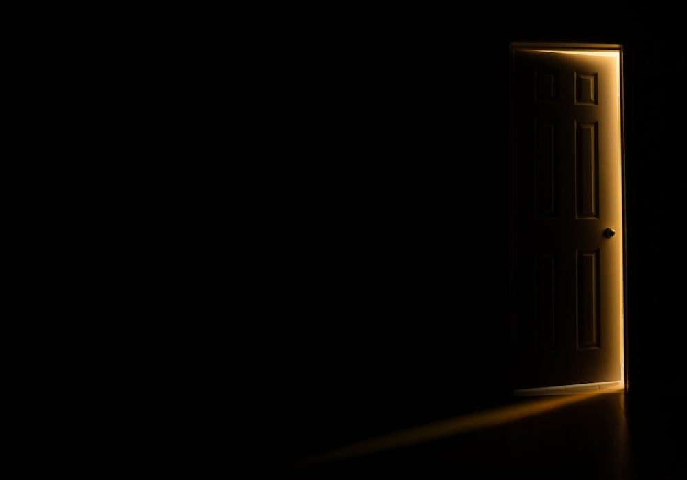 an open door in a dark room with light coming in