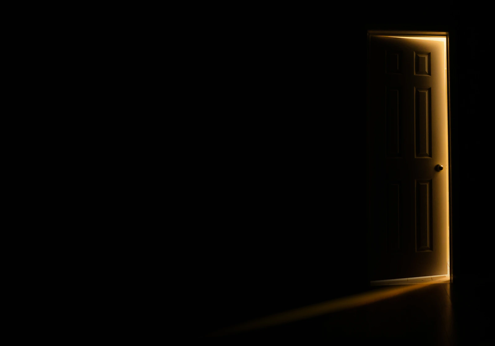 A slightly open door in a dark room with a thin line of light spilling in and no people in the frame, an illustrative real photo for Other Mommy, where something steps out of the dark in a child's bedroom