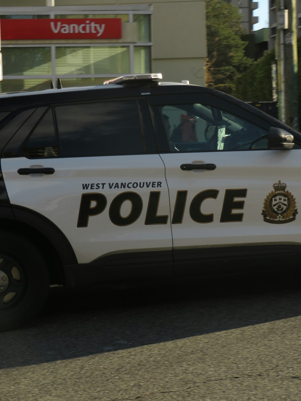 a west vancouver police car driving down a street