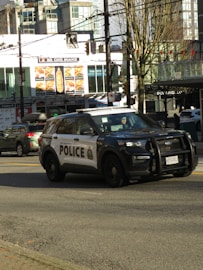 a police car driving down a street next to tall buildings