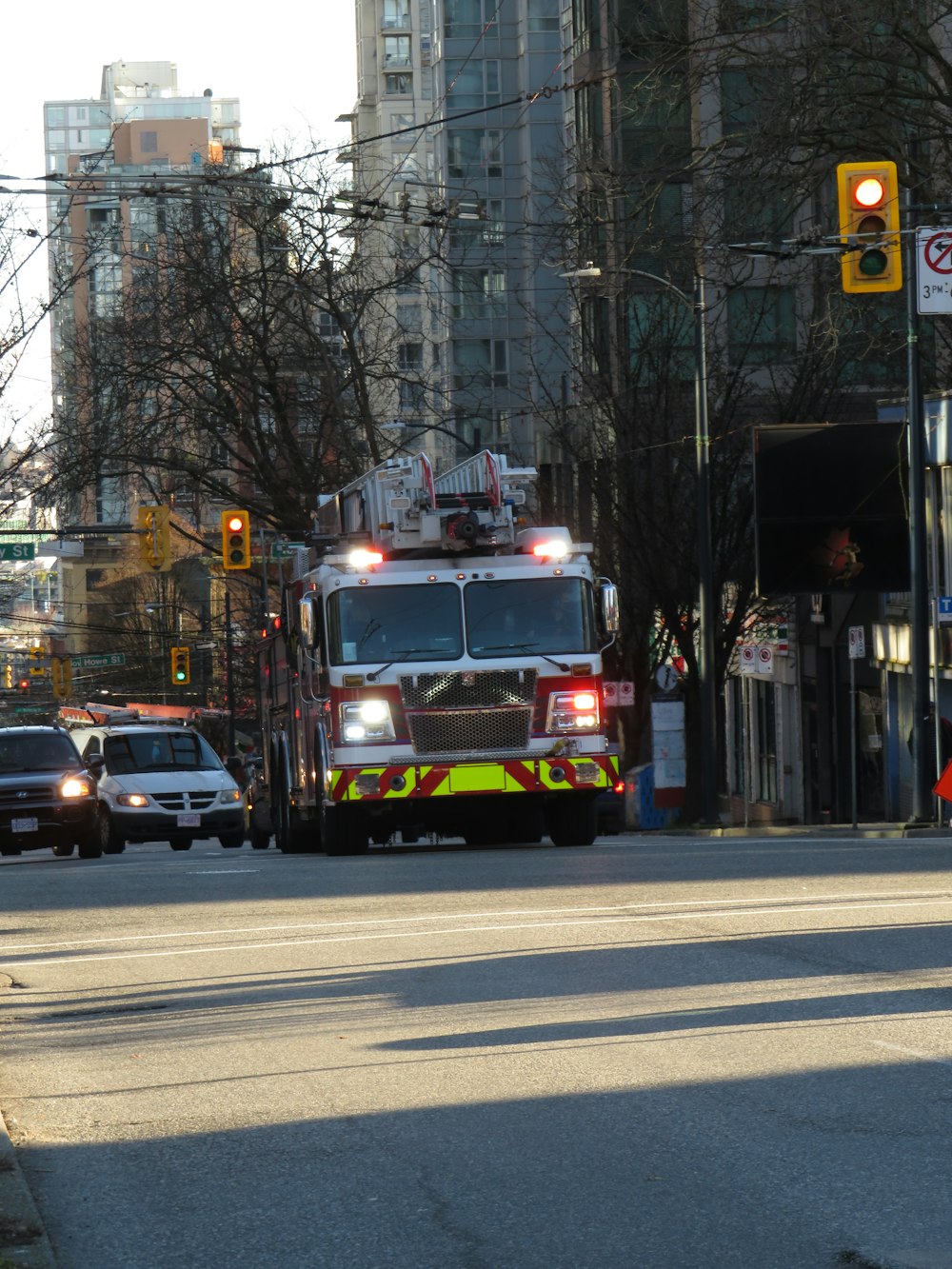 a fire truck driving down a street next to tall buildings