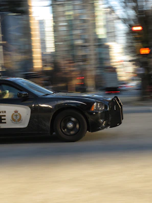 An intense chase scene with police cars and flashing sirens in the city.