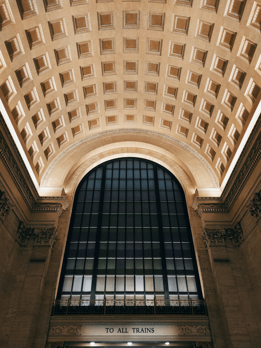 the ceiling of a train station with a clock on it