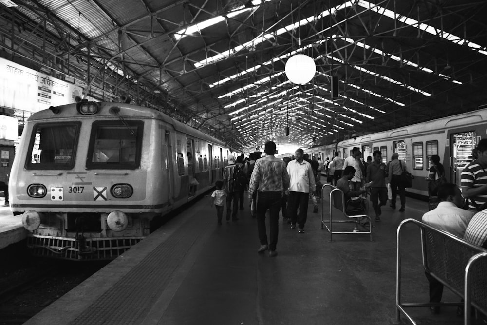 a black and white photo of people at a train station