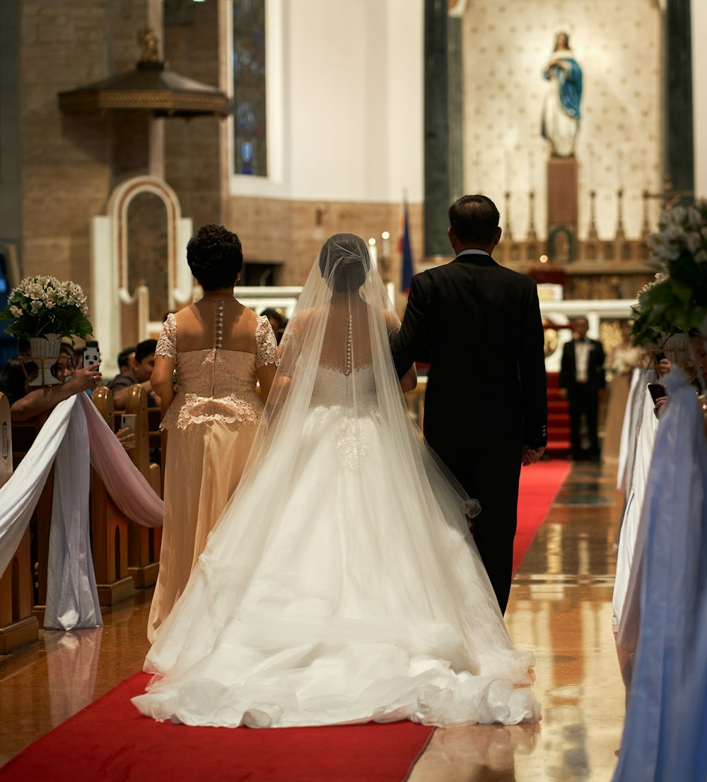 a bride and groom walking down the aisle of a church