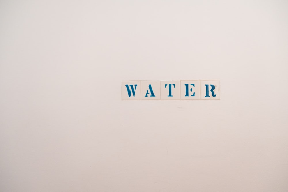 a white wall with a sign that says water on it