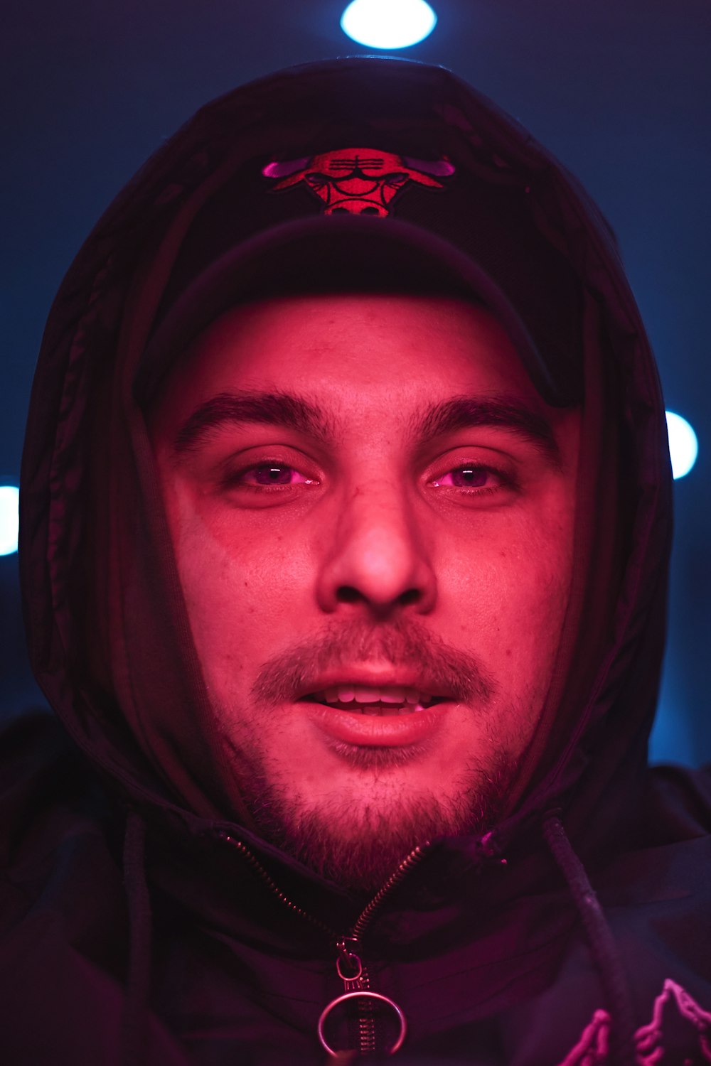 a man wearing a hoodie in a dark room