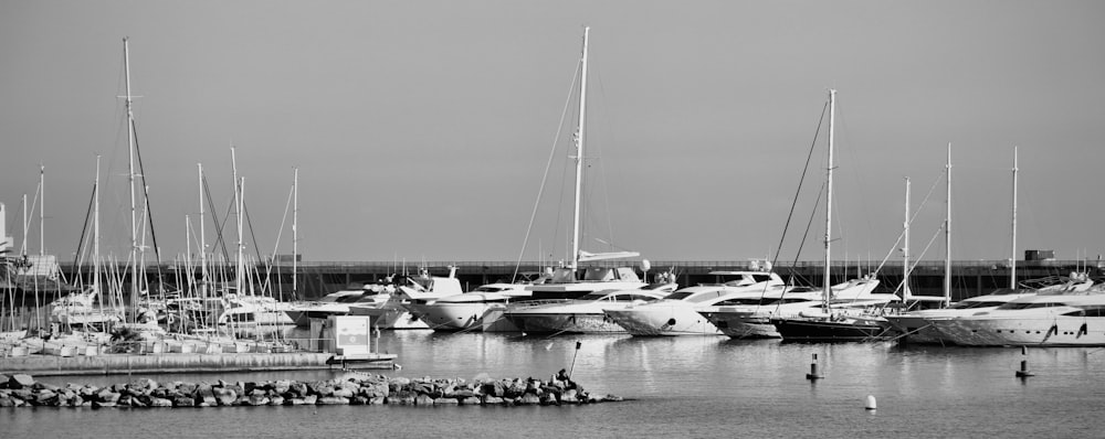 a black and white photo of boats docked in a harbor