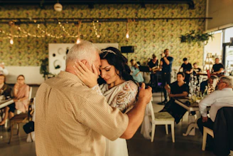 a man and a woman dance together in a room full of people