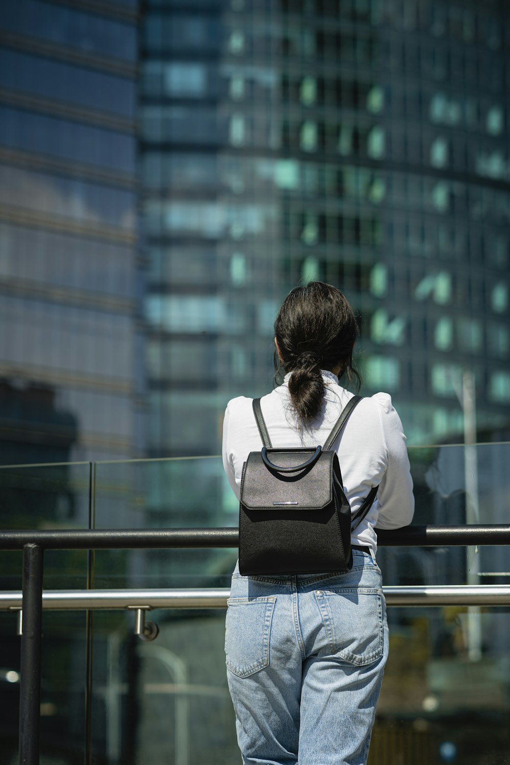 a woman standing on a balcony with her back to the camera