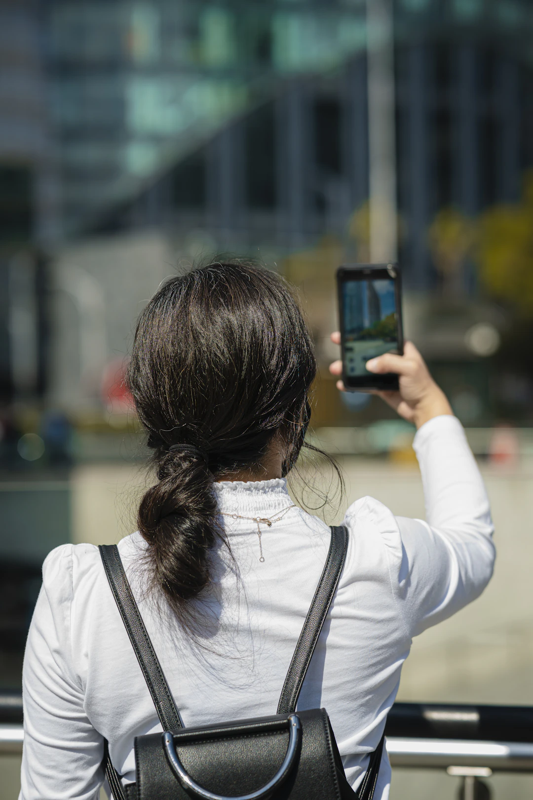 Person using a smartphone in a city away from a saved Android trusted place