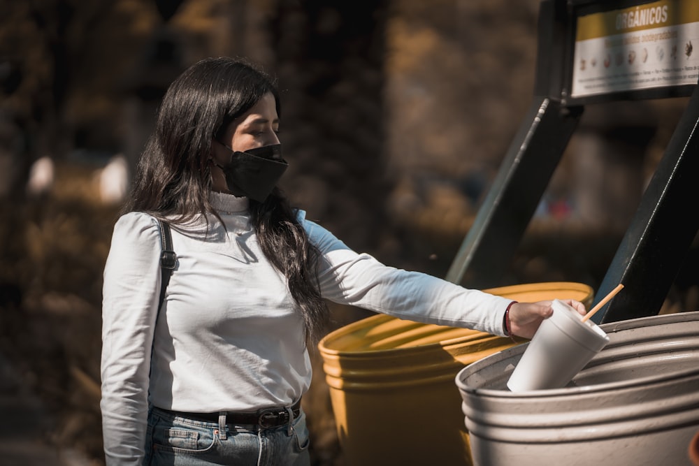 a woman wearing a face mask and holding a bucket