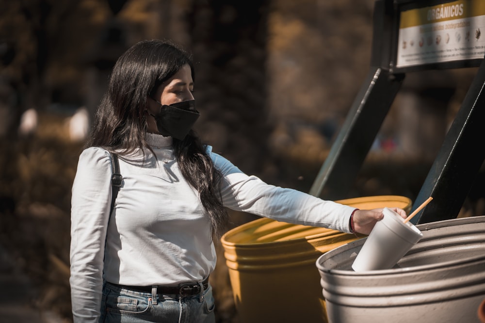 Una mujer con una máscara facial y sosteniendo un cubo