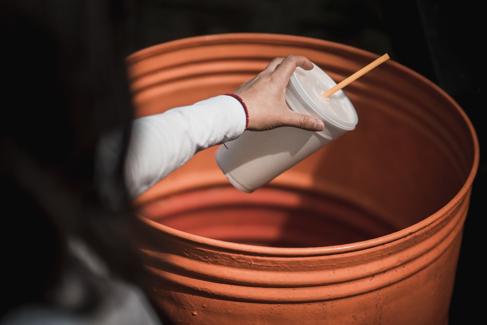 a person holding a cup with a toothpick in it