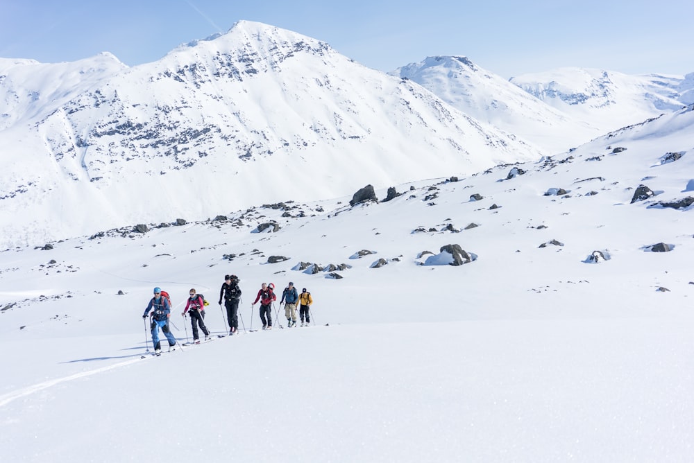 a group of people walking across a snow covered slope