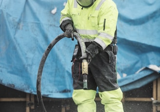 a man in a yellow uniform is using a hose