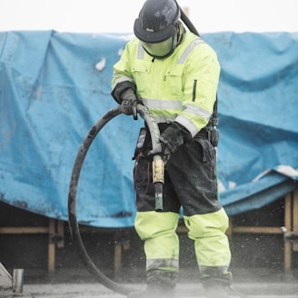 a man in a yellow uniform is using a hose