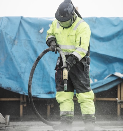 a man in a yellow uniform is using a hose