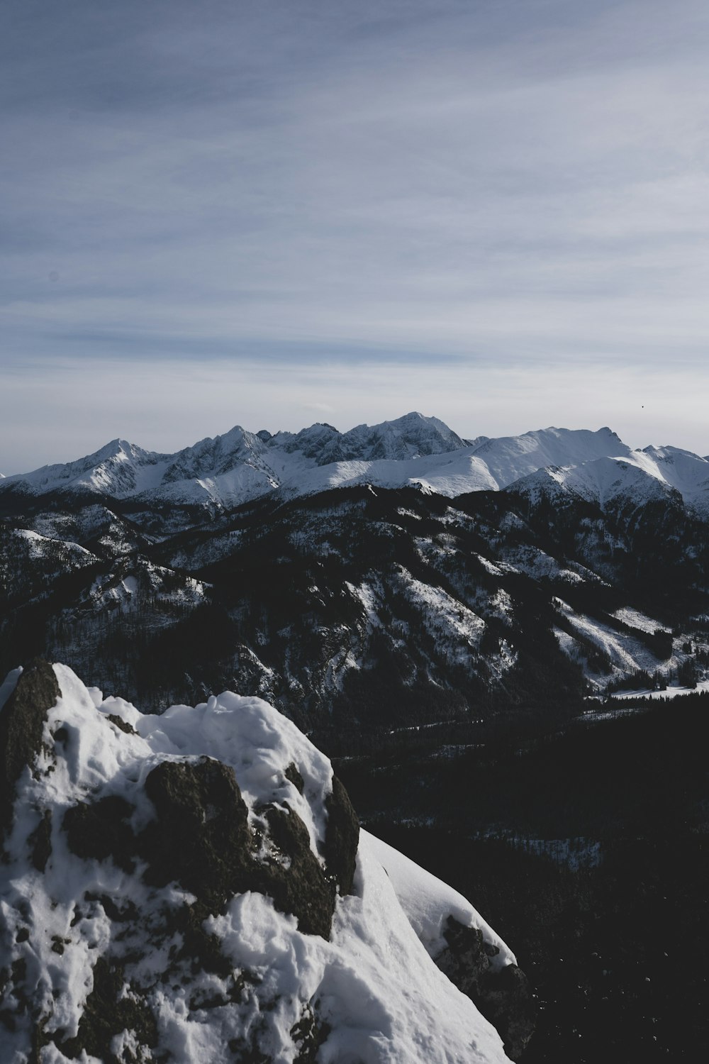 Una persona parada en la cima de una montaña cubierta de nieve