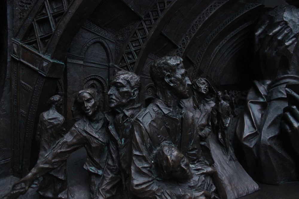 a statue of a group of people in front of a building