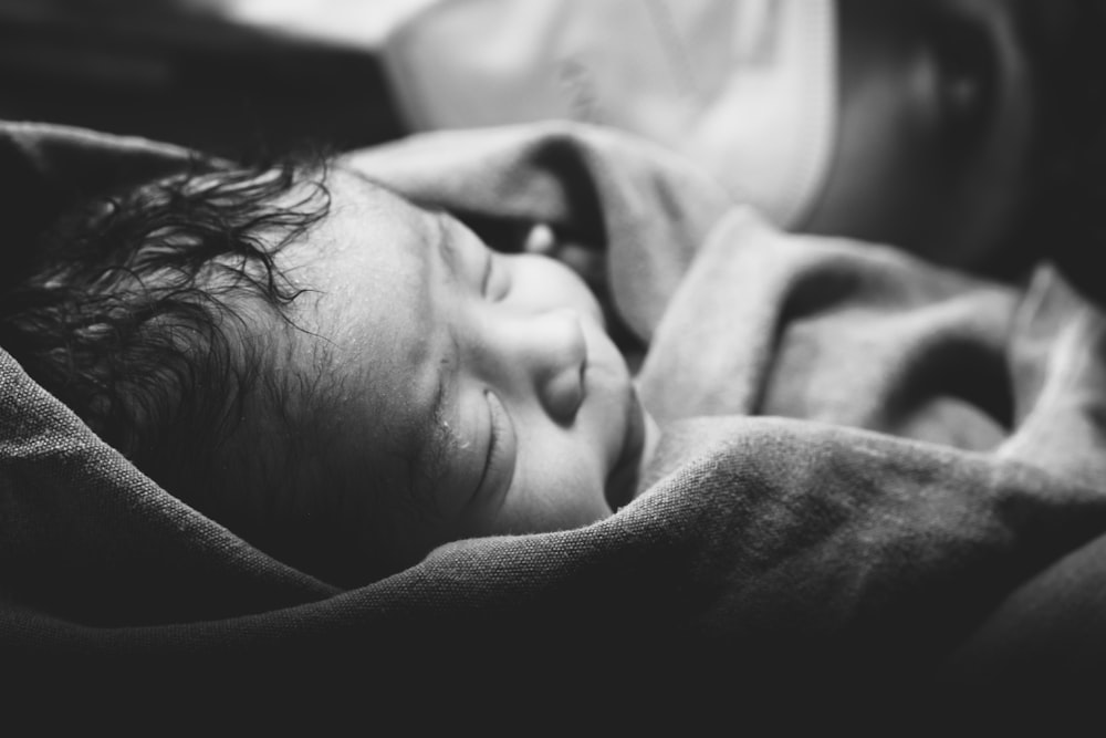 毛布に包まれた赤ちゃんの白黒写真