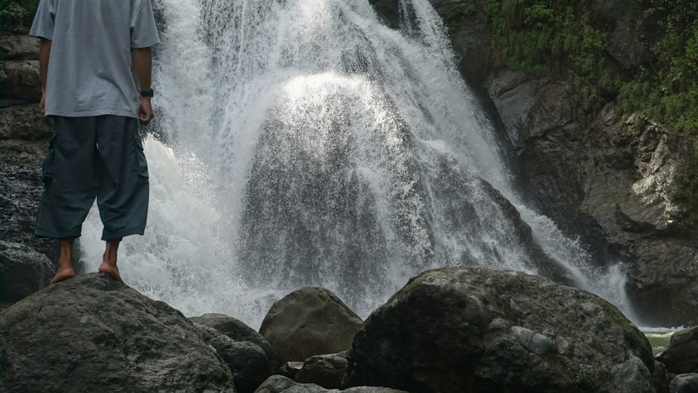 a man standing in front of a waterfall