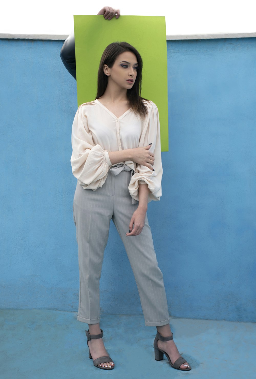 a woman standing in front of a blue wall