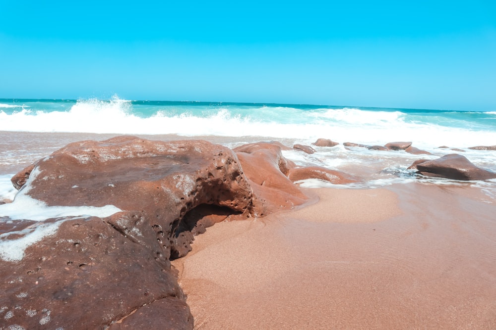 a sandy beach with waves coming in from the ocean