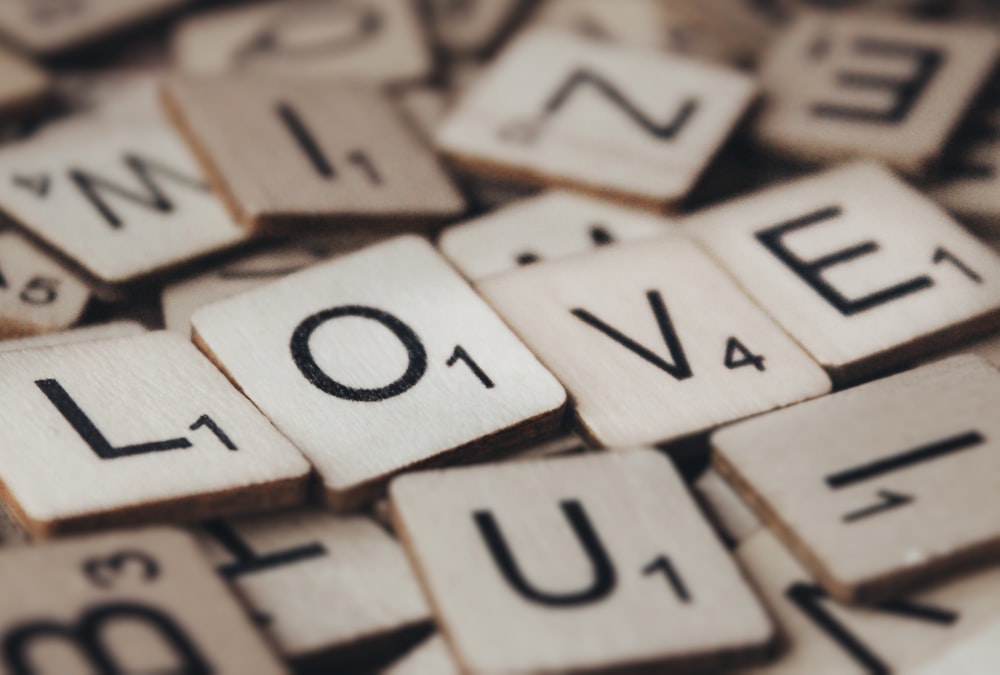 La palabra amor deletreada con letras de Scrabble