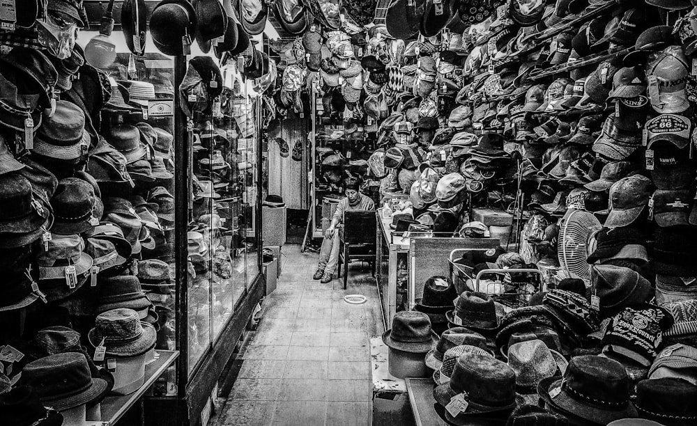 a black and white photo of a store filled with hats