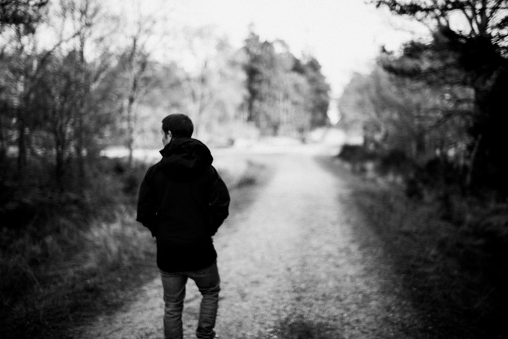 Una foto in bianco e nero di una persona in piedi su un sentiero