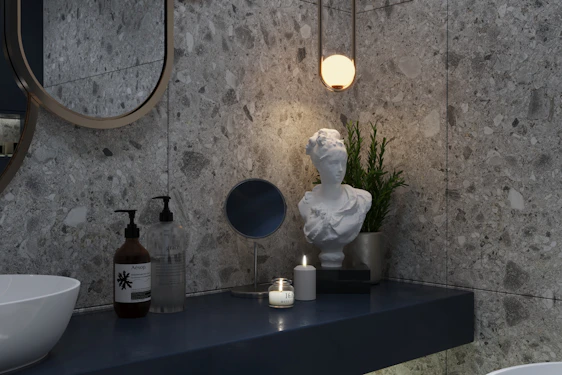 Close-up of finely crafted brass bathroom accessories arranged on a marble countertop with soft natural lighting.