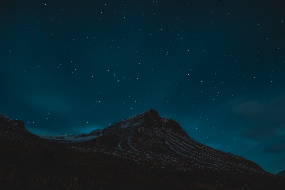 Un cielo notturno con stelle sopra una montagna