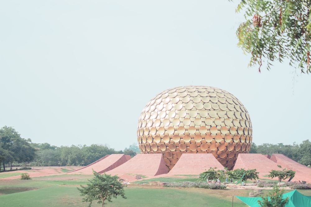 une grande structure en forme de boule au milieu d’un champ