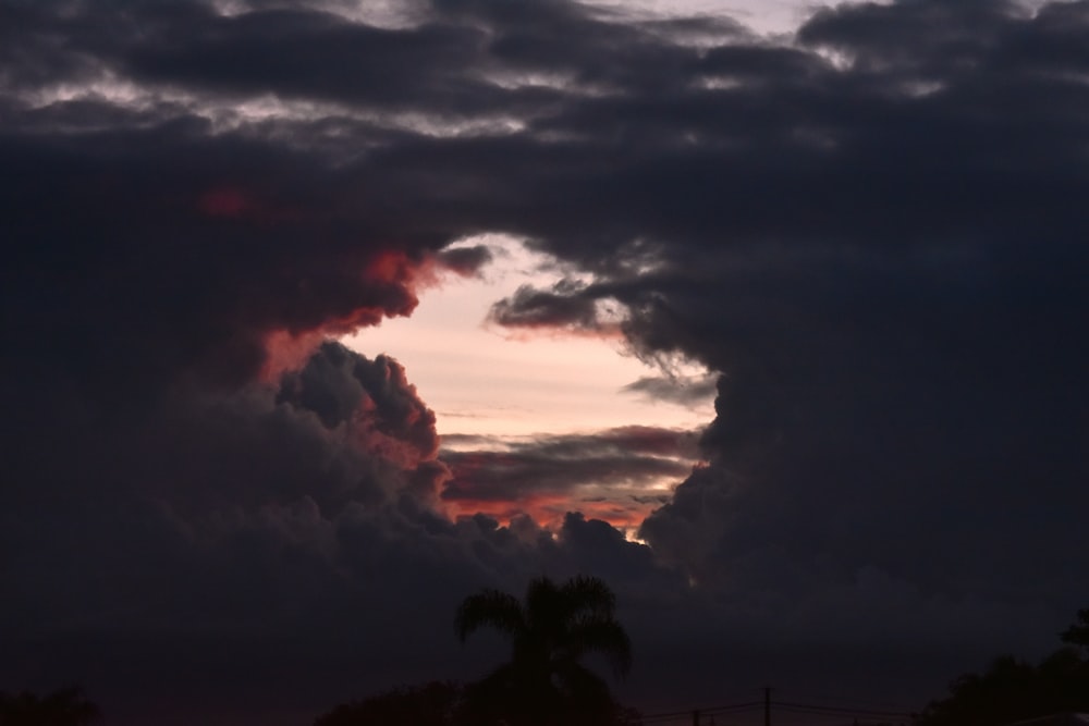 the sun is setting behind some clouds in the sky