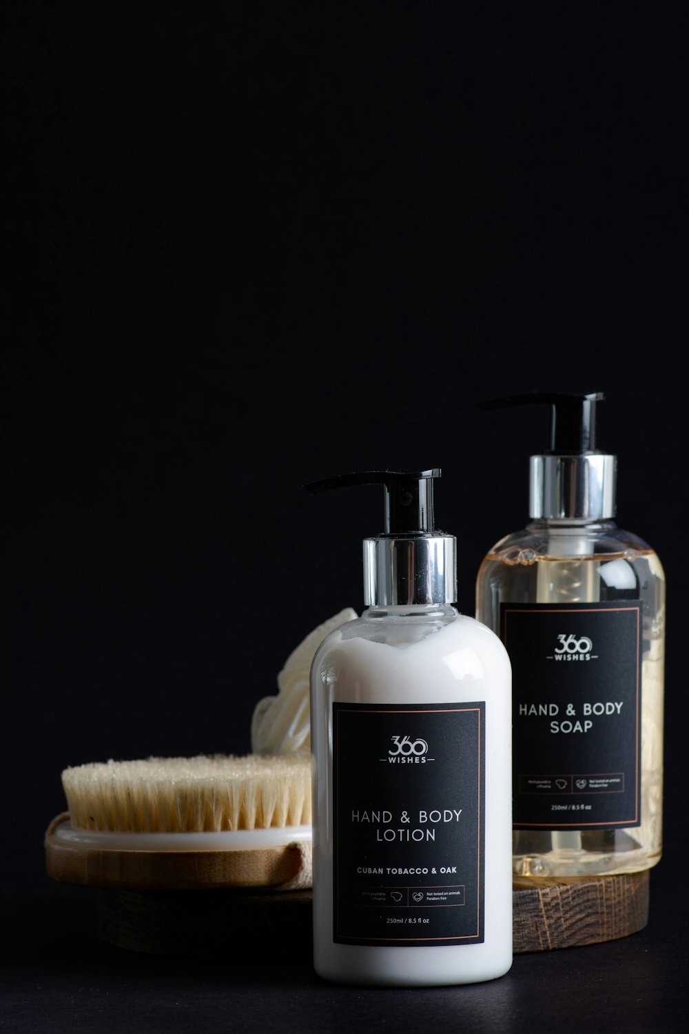 a bottle of hand and body lotion next to a brush