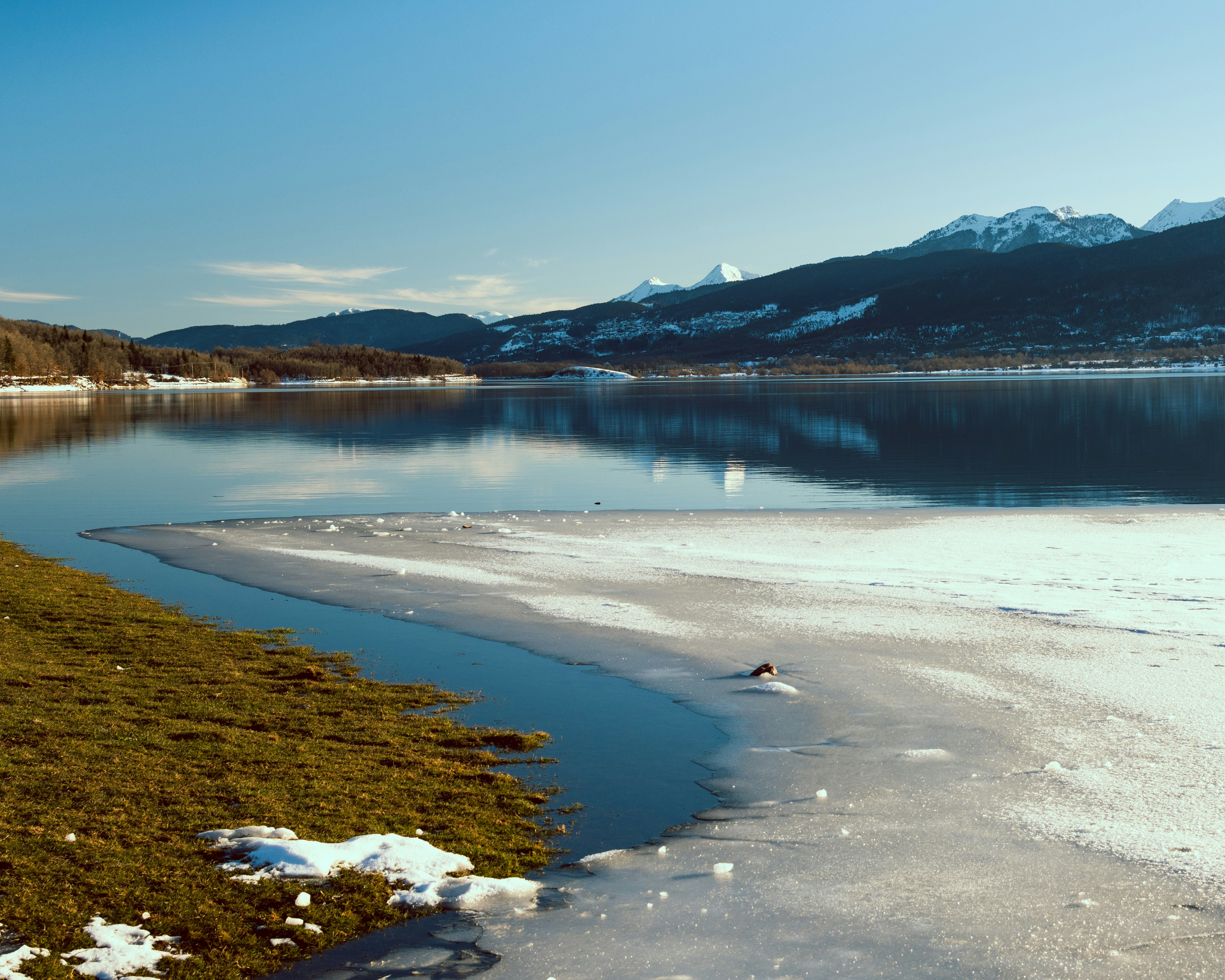 a body of water surrounded by snow covered mountains