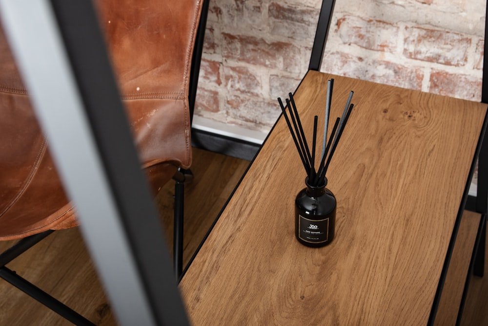 a wooden table topped with a bottle filled with candles