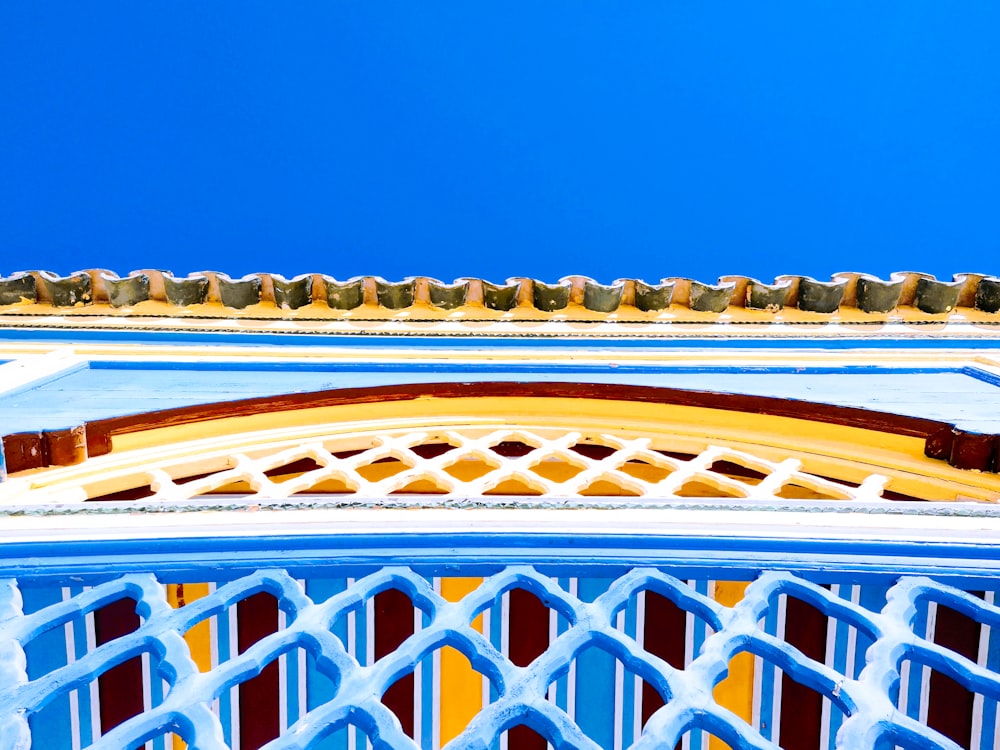 a blue and yellow building with a blue sky in the background