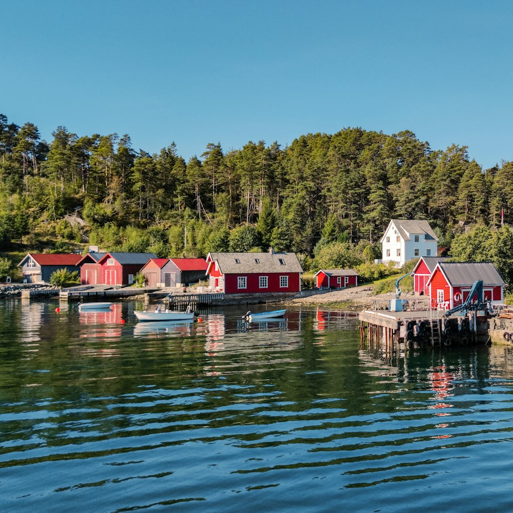 a row of red houses sitting on top of a body of water