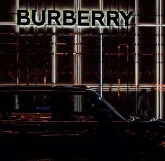 a black car parked in front of a burberry building