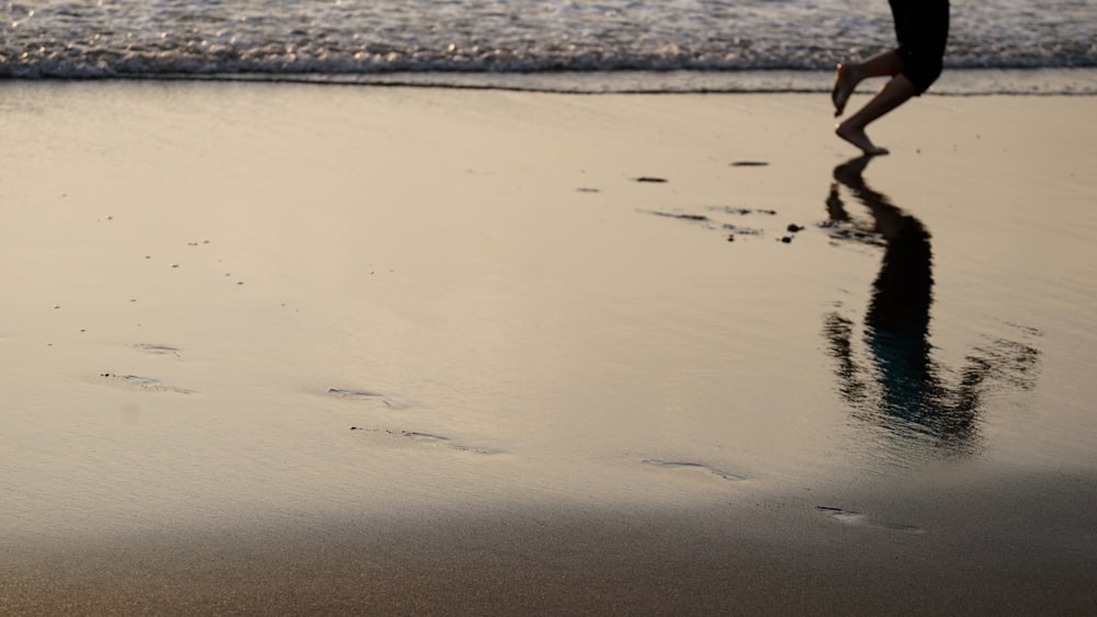 a person walking along a beach with footprints in the sand