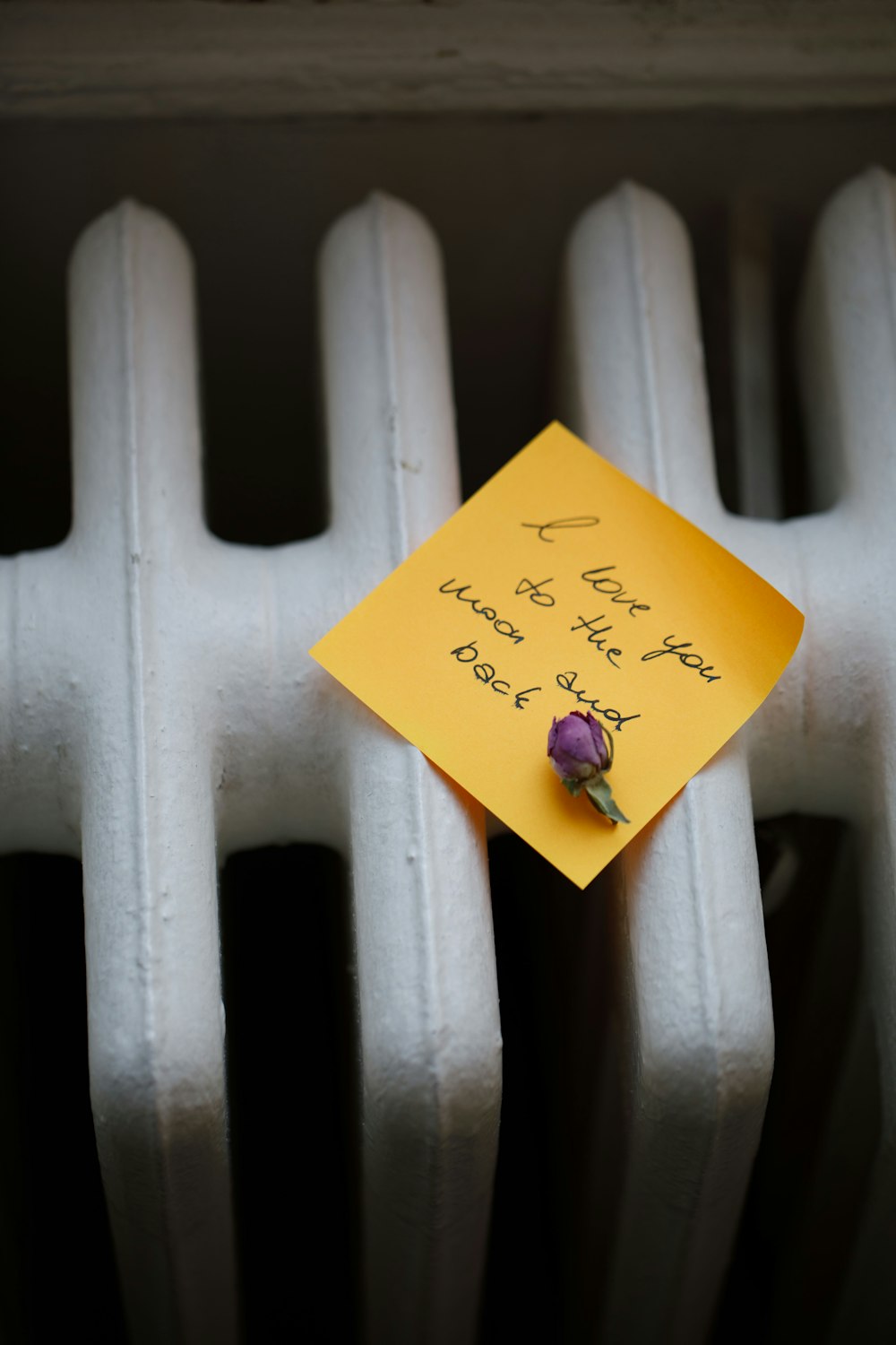 a yellow post it note attached to a radiator