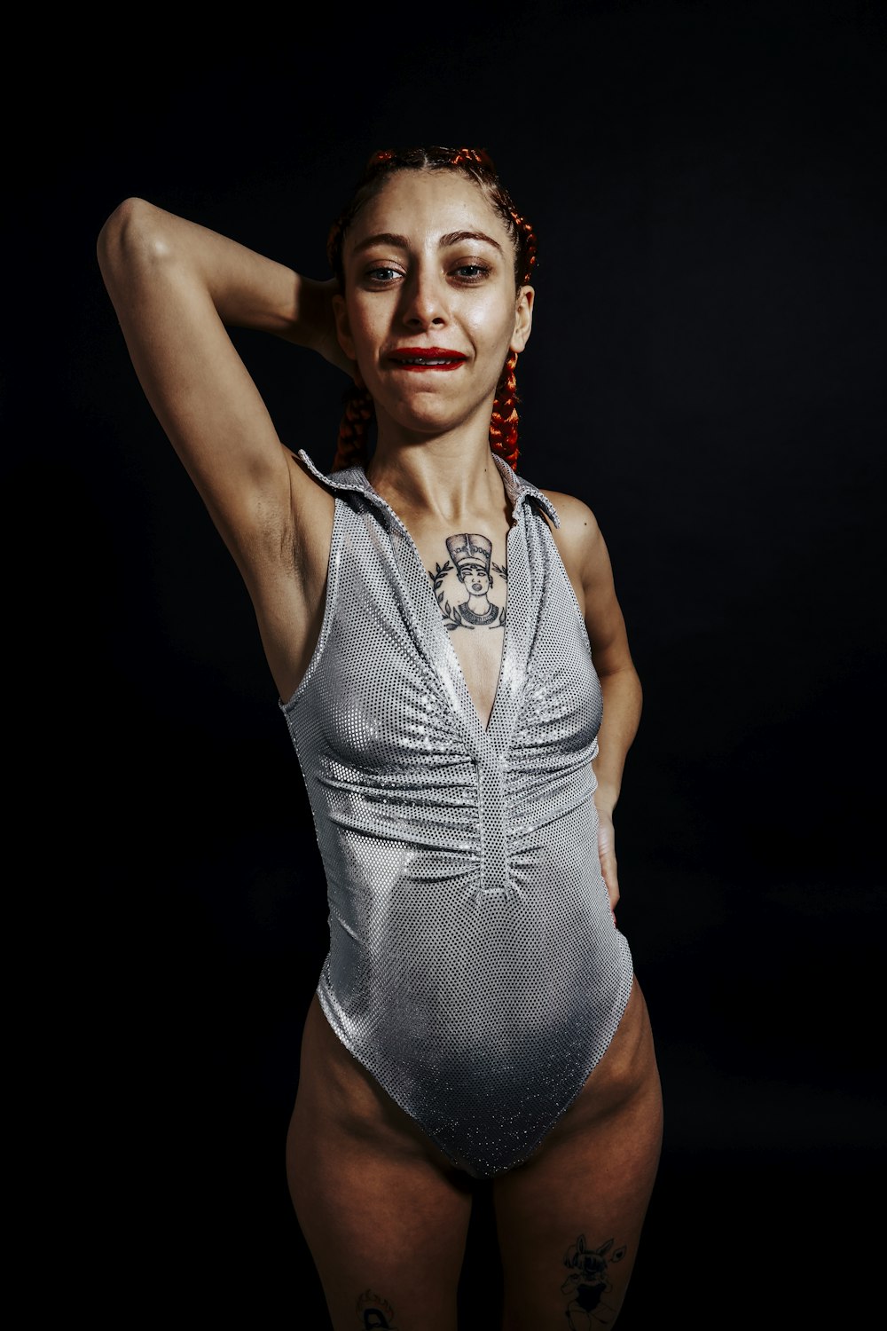a woman in a silver bodysuit posing for a picture